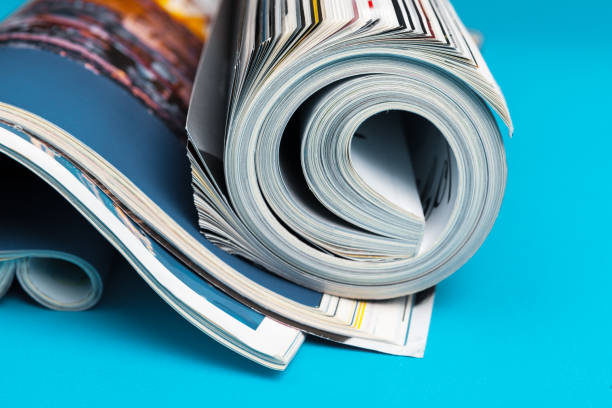 Freshly printed magazines rolled on a turquoise background